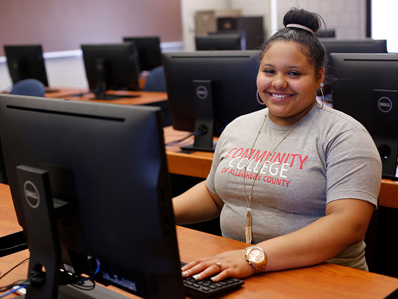 CCAC student sitting at a computer desk.