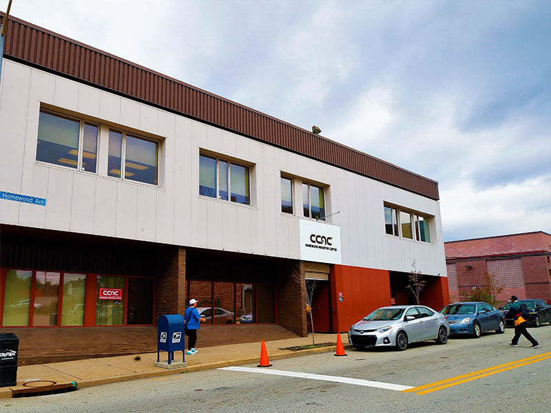 People walk outside the two-story CCAC Homewood-Brushton Center on Homewood Ave.