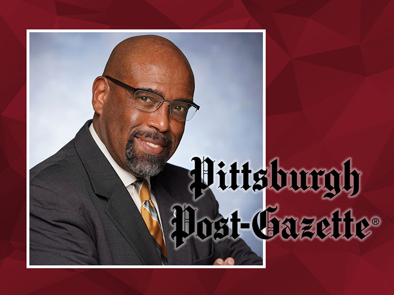 A portrait of CCAC President Dr. Quintin Bullock sits behind the logo of the Pittsburgh Post-Gazette.