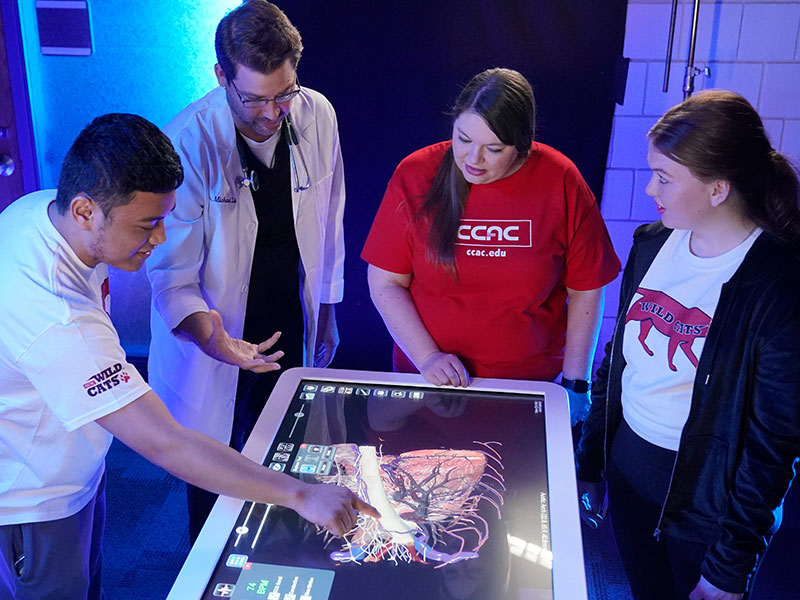 CCAC student Jessica Wheeler studies an Anatomage table alongside classmates. Wheeler was interviewed for the Pittsburgh Post-Gazette’s article about how the college is meeting the community’s workforce training needs.
