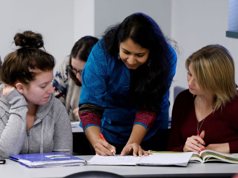 A CCAC instructor assists students in the classroom.